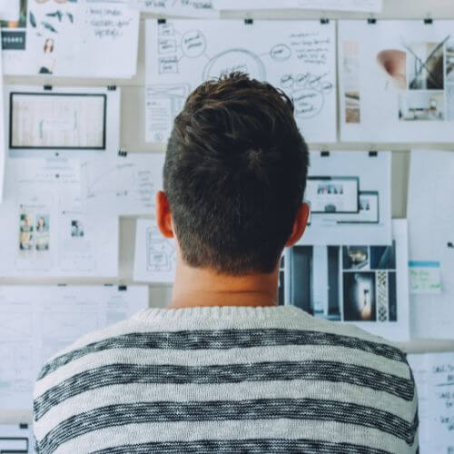 A person standing in front of a board analyzing the details